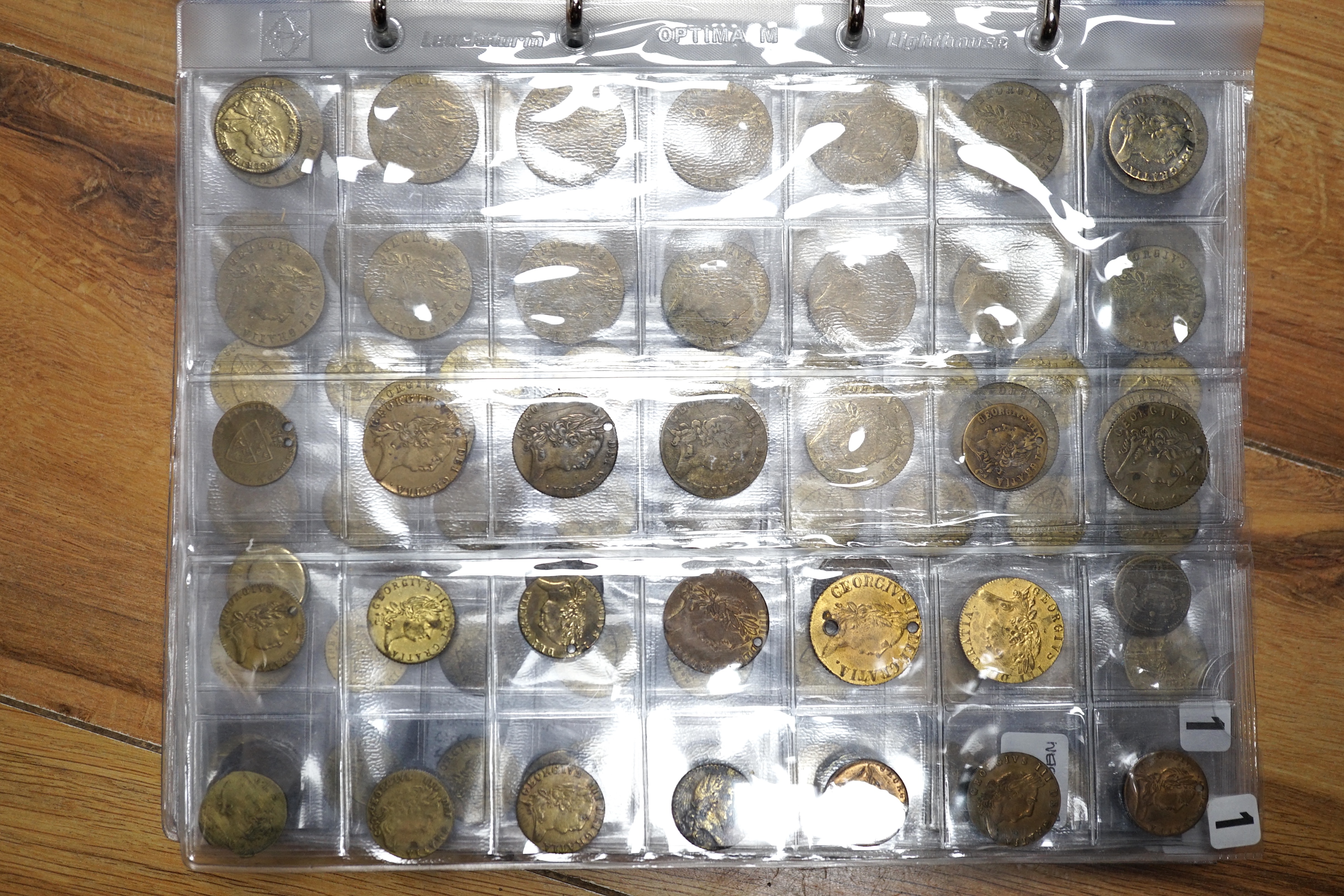 A large collection of halfpenny tokens and gaming tokens, 17th to early 20th century, in an album